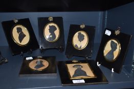 A set of six early Victorian hand painted silhouettes in gilt and ebonised frames with acorn and oak