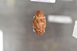 An early 20th century Japanese wooden carved Ojime bead in the form of a man holding a flute
