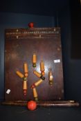 An early 20th century table top skittles set in wood with score board