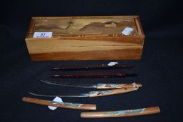 A 20th century wooden box container with inlayed detail of a scenic landscape, with some contents