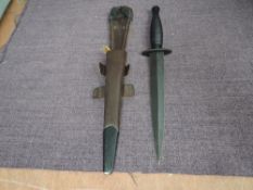 A Fairburn Sykes 3rd Pattern Commando Knife with leather and metal scabbard, blade length 18cm