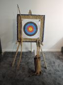 A modern Yew Wood Long Bow with arrows, target and stand