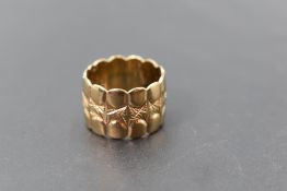 A 9ct gold wedding ring having moulded and engraved decoration, size N & 7.8g