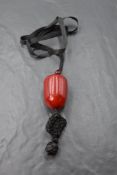 A large cherry amber ojime bead on black chord