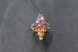 A multi coloured (fancy) sapphire ring being set with 7 rows of stones in a lozenge panel mount to