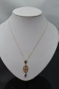 A 9ct gold Art nouveau style pendant with diamond chip and amethyst detail on a 9ct gold chain,