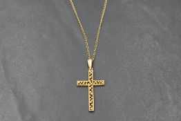 A 9ct gold cross pendant having beaded decoration and matt finish, on a gold plated chain