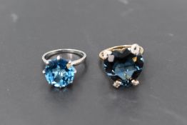 An over sized heart shaped, heat treated blue topaz ring having claw set mount spelling out the word