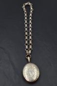 A large Victorian white metal locket having engraved foliate decoration on a white metal large