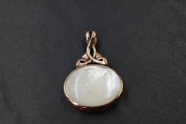 A large fob style pendant having mother of pearl and lapiz lazuli style panels in a 9ct rose gold