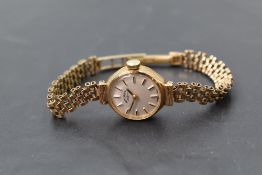 A lady's 9ct gold wrist watch by Rotary having a baton dial to champagne face in gold case with long