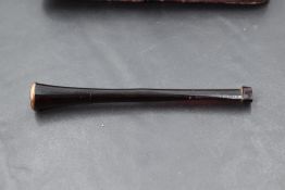A cased red bakelite cigarette holder having rose gold tip, no marks