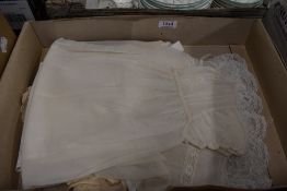An early 20th century christening shawl having embroidered details with a similar shawl and apron