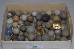 A selection of antique games counters balls marbles and shot pieces in glass stone and ceramic