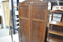 An early 20th Century dark oak wardrobe with shelf and cupboard storage