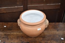A terrracotta planter having glazed interior and mask handles