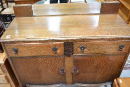 An early 20th Century oak sideboard having low mirror back