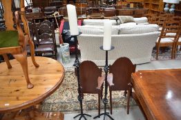 A pair of wrought iron candle stands with pillar candles