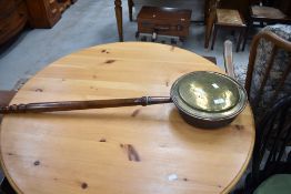 A traditional brass and copper warming pan