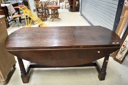 A reproduction oak banquetting style drop leaf table on chunky frame, large proportions