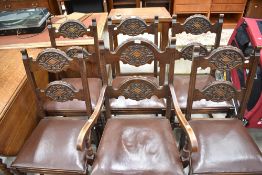 A set of five dark oak dining chairs with an additional carver chair having carved double backs