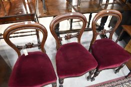 Three Victorian balloon back dining chairs with carved details and turned legs