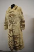 A vintage 1960s full length cream and brown fur coat.