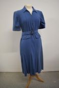 A blue wool 1940s day dress having belt to waist, metal zip to centre front, and vented skirt,
