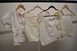 Four Victorian corset covers, all having intricate detailing throughout.
