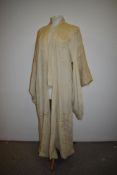 An early 20th century cream silk kimono dressing gown having cherry blossom and birds embroidered