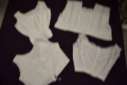 Four Victorian corset covers, all having intricate detailing throughout.