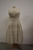 A late 1950s early 1960s cream strapless dress having sequin and diamante detailing throughout.
