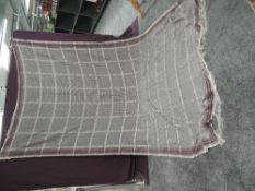 A Victorian crinoline shawl having fringed edges and bright pink, green, blue and red patterns on