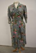 A 1940s duck egg blue dress having rose pattern in pink, side metal zip, three quarter length