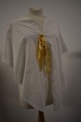 A Victorian fine Broderie Anglais bed jacket with scalloped edges and silk ribbon detailing.