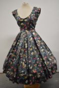 A 1950s floral polished cotton day dress having low scoop neckline and very full skirt.