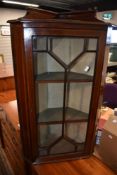 An Edwardian mahogany corner wall cabinet
