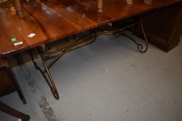 A modern hardwood extending dining table on metal work frame