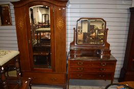 An Edwardian mahogany wardrobe having inlaid decoration including cherub cartouches, and a
