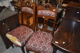 A pair of Victorian mahogany high back dining chairs having upholstered seats and shoulder rails