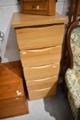 A modern beech laminate narrow chest of five drawers