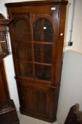 A Priory style corner display having linen fold decoration to door