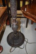 A heavily carved standard lamp , having vine decoration
