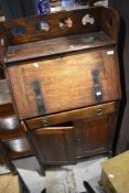 An Arts and Crafts bureau having medieval revival style detailing