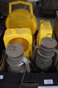 Three portable road warning lights and two vintage storm lamps.