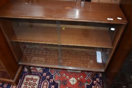 A vintage sapele bookcase having sliding doors
