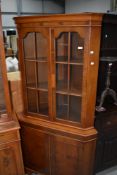 A reproduction yew wood corner display having cupboard under