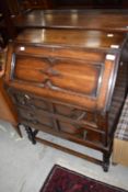 An early 20th Century oak bureau on stile frame with twist legs