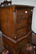 A reproduction serpentine chest of narrow proportions