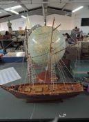 A wooden model Sailing Boat on stand along with a modern reproduction Globe also on stand